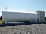 White horizontal above-ground fuel or water tank on a gravel surface, accompanied by a containment unit.