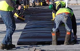 Concrete blankets being deployed on a construction job site