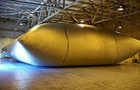 Large industrial-grade water storage bladder tank in a warehouse or facility for high-capacity liquid storage.